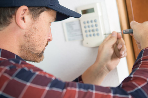 HVAC technician working on thermostat