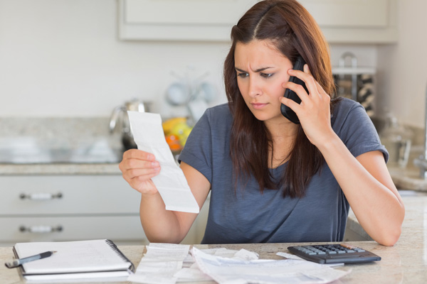 image of woman paying her energy bill and home heating costs