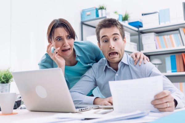 couple checking expensive HVAC service bill