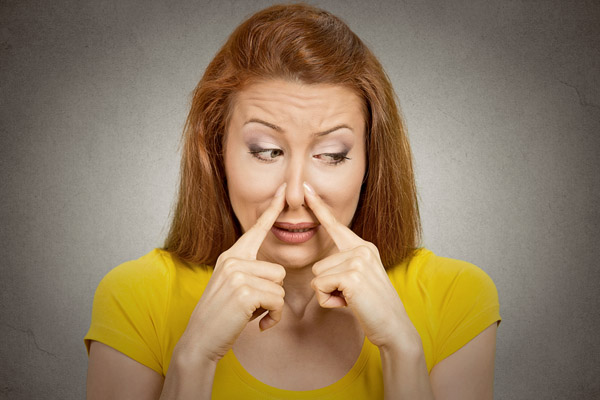 image of a homeowner plugging nose due to dead animal in ductwork