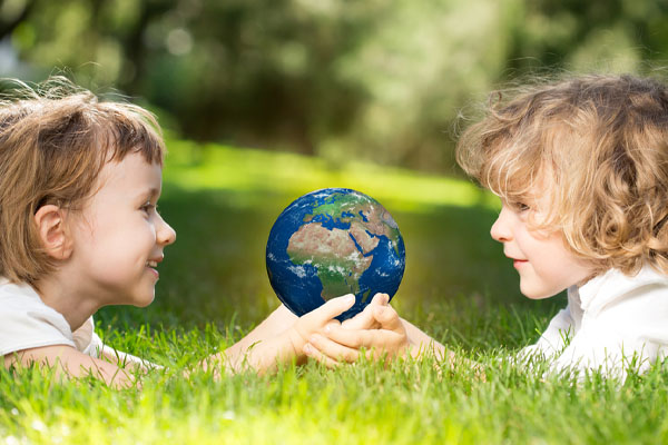 image of girls holding earth depicting why carbon emissions should matter