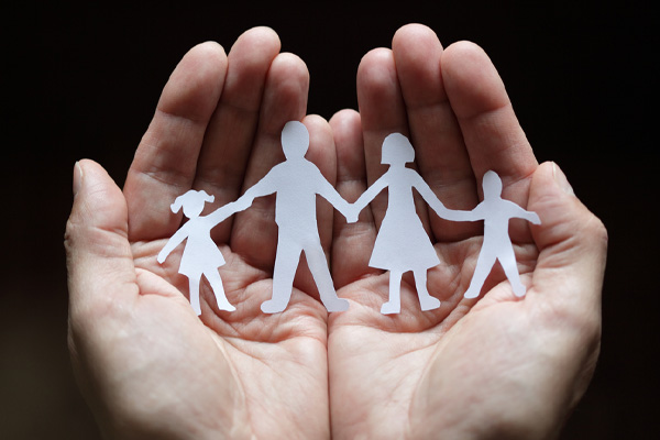 image of paper cut out of family in hands depicting propane heating safety