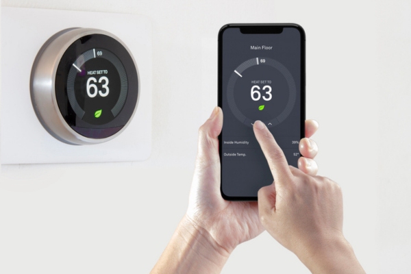 homeowner synching smart thermostat to smart phone