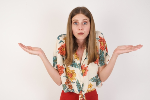 Puzzled and clueless young woman with arms out depicting What MERV Ratings Indicate