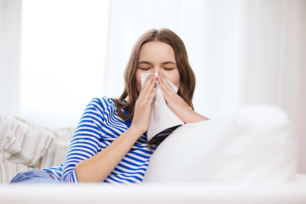 girl sneezing on a tissue depicting How MERV Ratings Influence Indoor Air Quality