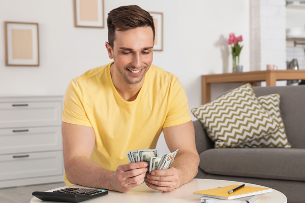 happy man counting savings after installing new air conditioner with high seer rating