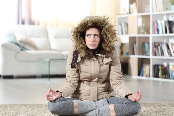 image of a homeowner feeling chilly due to furnace turns on but no heat