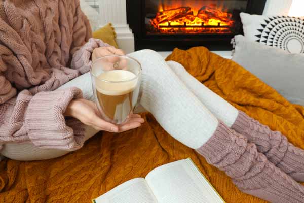 image of a woman sitting by a propane gas fireplace