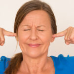 image of homeowner covering ears due to air conditioner noises