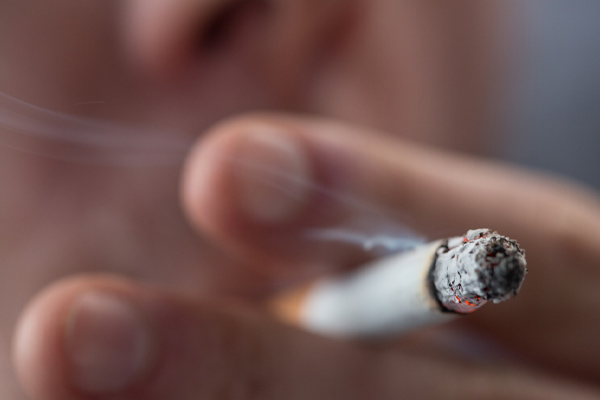 person smoking cigarette indoors depicting air conditioner smell