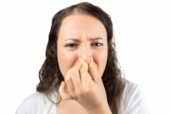 woman plugging nose due to smelly air conditioner