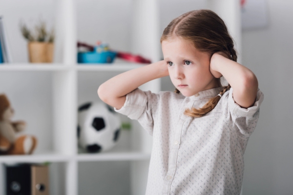 child covering ears due to noisy window air conditioner