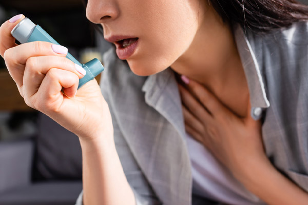 image of homeowner using inhaler due to poor air quality at home