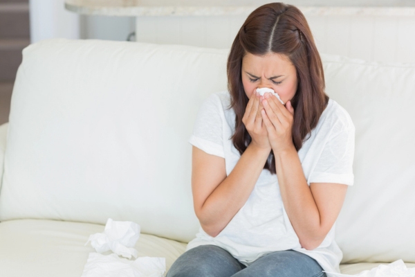 woman sneezing due to poor indoor air quality
