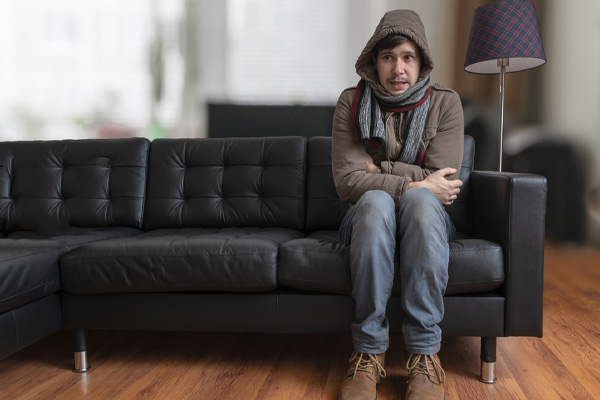 image of homeowner feeling chilly due to furnace system shutdown