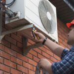 Professional worker replacing outdoor AC unit