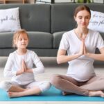 pregnant mom and young daughter practicing indoor yoga