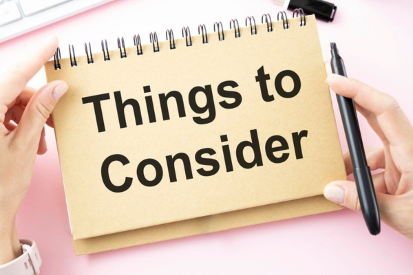 things to consider written on a notebook depicting air conditioner repair vs replace