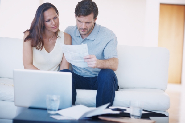 couple looking stressed while looking at their increase energy bill