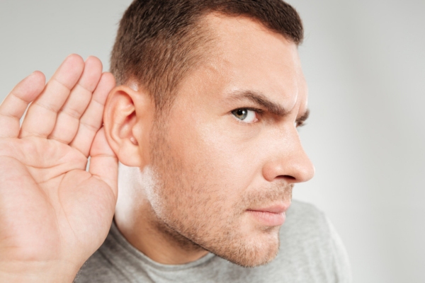 homeowner cupping right ear trying to listen to Unusual Noises from the Ducts