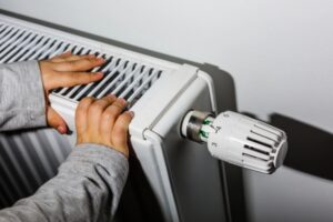 kid's hands feeling the warmth from a heating oil radiator