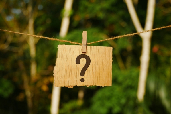 question mark on a torn paper clipped and hanging on a thin rope depicting Furnace Blower Keeps Running But No Heat FAQS