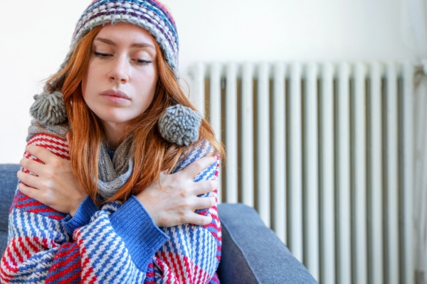 woman feeling cold at home having heating problem