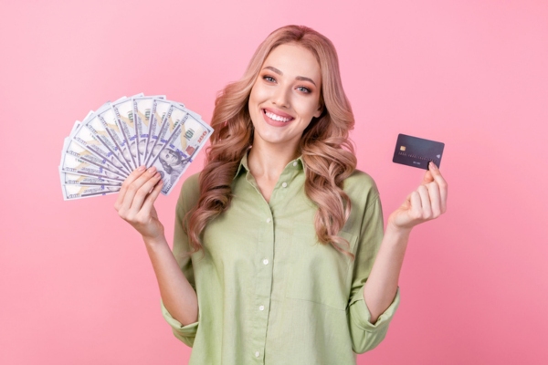 woman holding dollar bills and credit card on each hand depicting Heating Oil Payment Solutions