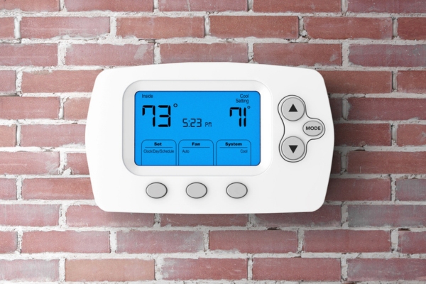 programmable thermostat installed on a brick wall
