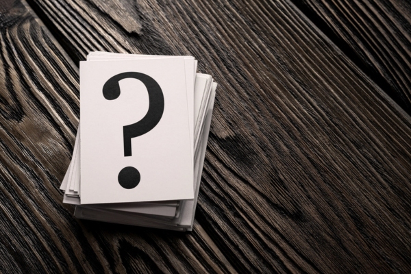 Stack of question mark cards on the wooden table depicting Air Conditioner Care FAQs