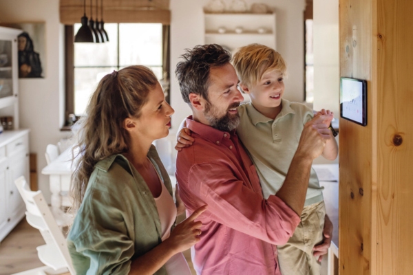 family adjusting smart home thermostat