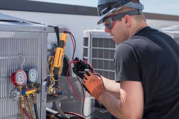 HVAC technician repairing central air conditioner
