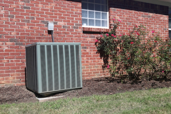 central air conditioner installed against a red brick wall