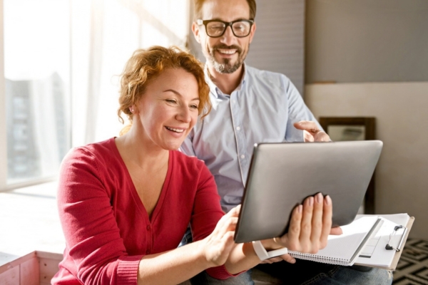 couple looking at smart tablet depicting Choosing Smart HVAC Technology for Your Home