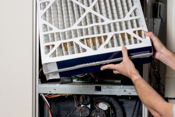homeowner replacing furnace filter
